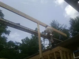 Carpenter setting a ridge beam over a new addition frame — Ice Dam Removal by Roofing Brothers in Hadley